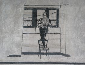 EIn Karzerinsasse blickt aus dem Fenster auf die Stadt Freiburg.